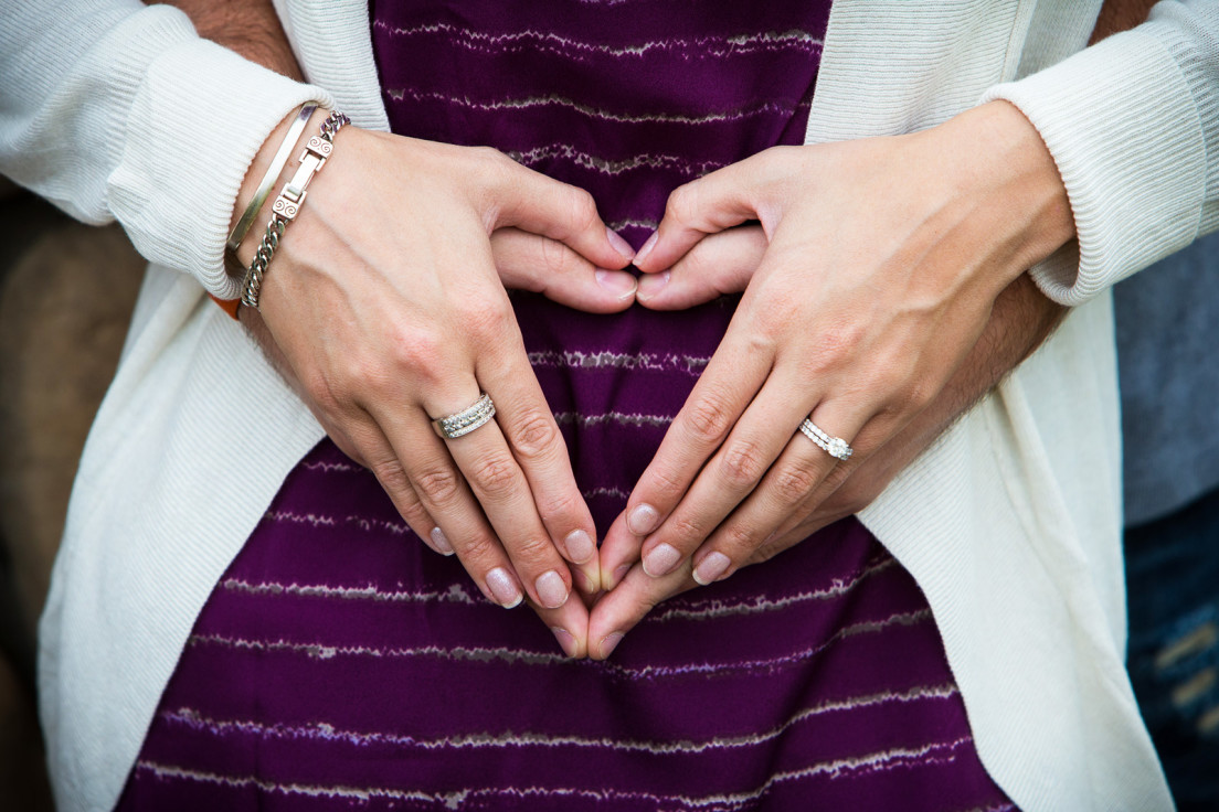 Engaged couple making heart with hands