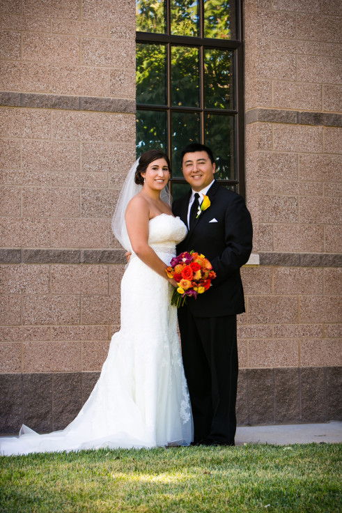 Bride and groom posing outside church